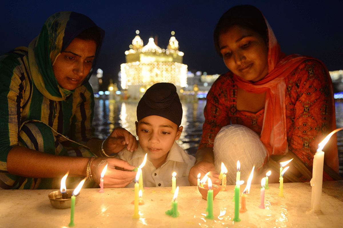 Sikhit sytyttämässä uudenvuoden kynttilöitä Armitsarin kultaisessa temppelissä Intiassa. Baisakhi-juhlaa eli sikhien uuttavuotta vietettiin 14.4. Sikhiläisyys on 1500-luvulla syntynyt yksijumalainen intialainen uskonto. Sikhiläisissä pyhissä kirjoituksissa Jumalaa kuvaillaan muun muassa Äidiksi, Isäksi, Rakkaaksi, Puolisoksi ja Ystäväksi.